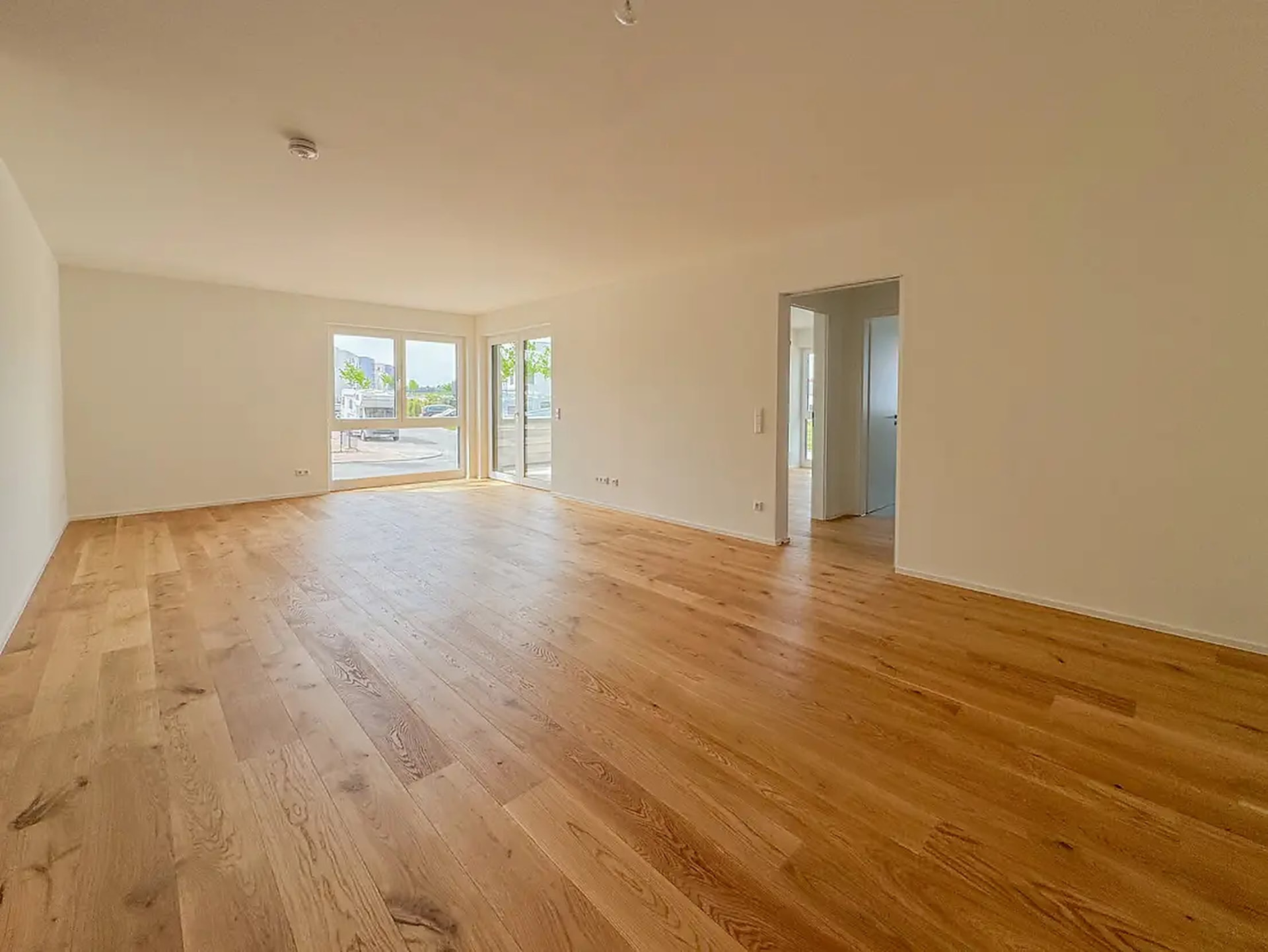 Wohnraum mit Eichenparkett und Blick zur Terrassentür