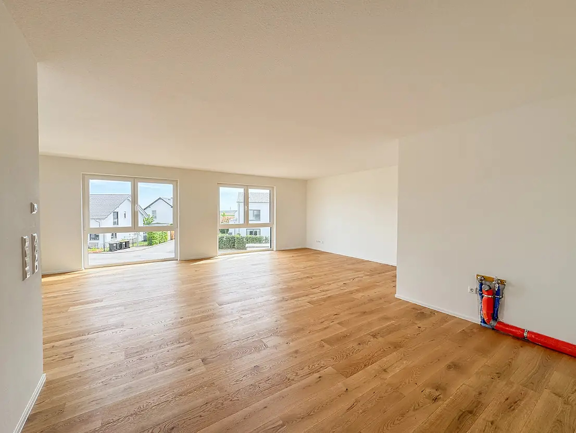 Offener Wohnbereich mit zwei Fensterfronten